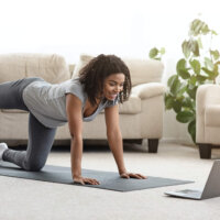 Fit Young Woman Excersising At Home, Watching Video Tutorial On Laptop Online Training. Fit Young Woman Excersising At Home, Watching Video Tutorial On Laptop